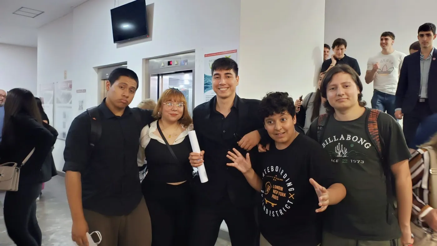 Fabián con su diploma junto a compañeros de la facultad