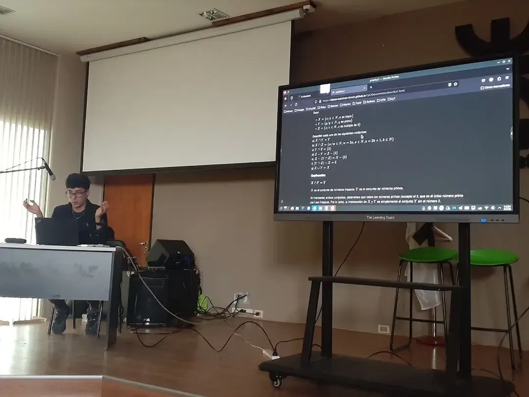 Fabián explicando en una clase con pantalla